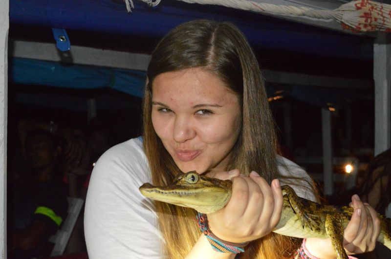 Austauschschülerin hält ein kleines Krokodil in Brasilien
